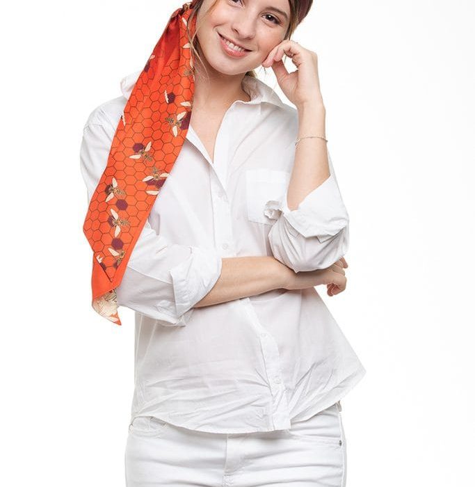 Designer Melissae silk twilly in sophisticated maroon, showcasing the artistic bee and honeycomb pattern. A unique statement piece of wearable art.