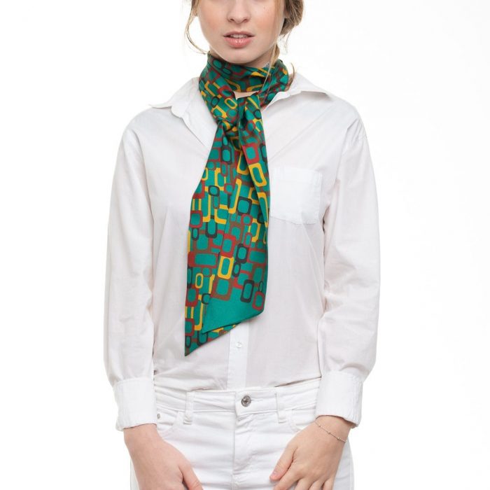 Model wearing the versatile Links twilly around the neck, emphasizing the bright green background against the outfit. Essential accessory for all seasons.