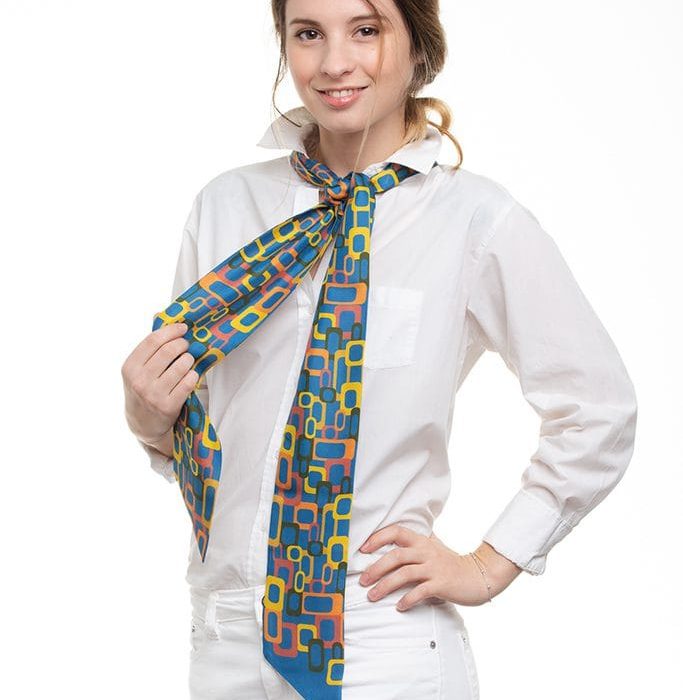 Folded collection of Links twillies, emphasizing the beautiful contrast between the ocher links and the rich blue silk background.