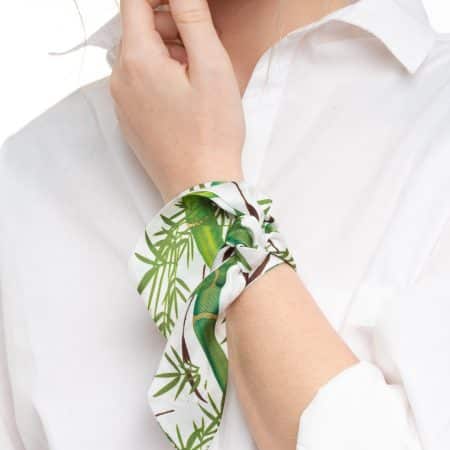 Accessory shot: Silk twilly bamboo print tied on a black handbag