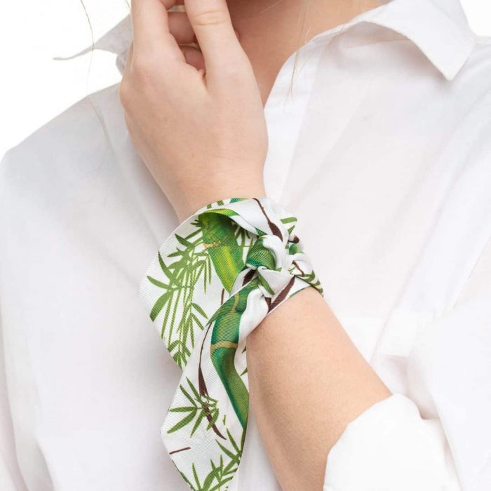 Accessory shot: Silk twilly bamboo print tied on a black handbag