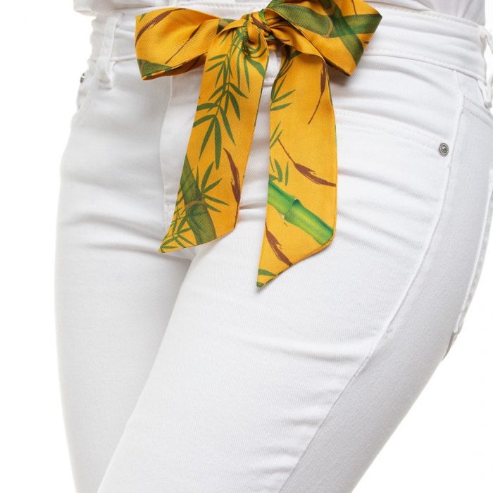 Model wearing the Bamboo silk twilly as a bow, emphasizing the natural green and ocher palette. Luxury accessory for all seasons