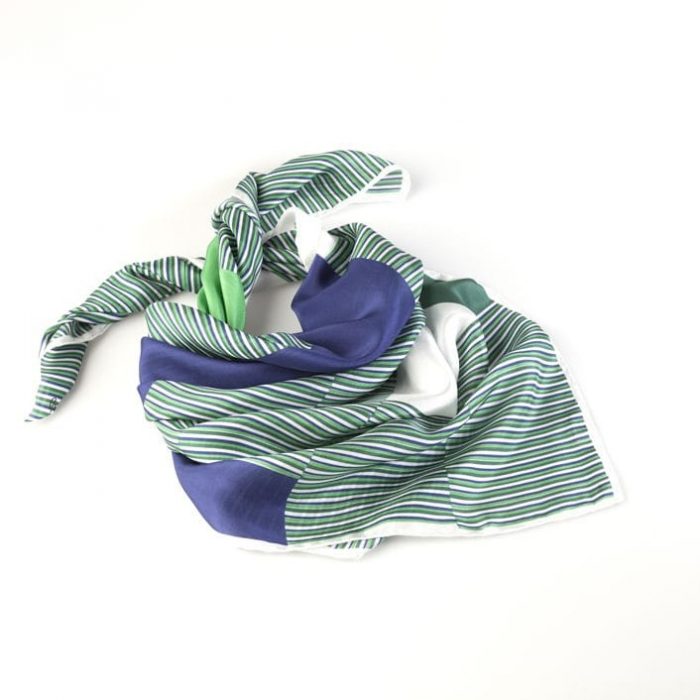 Folded 'Farewell' scarf, emphasizing the tribute to the light and colors of the sea through the green, blue, and white palette