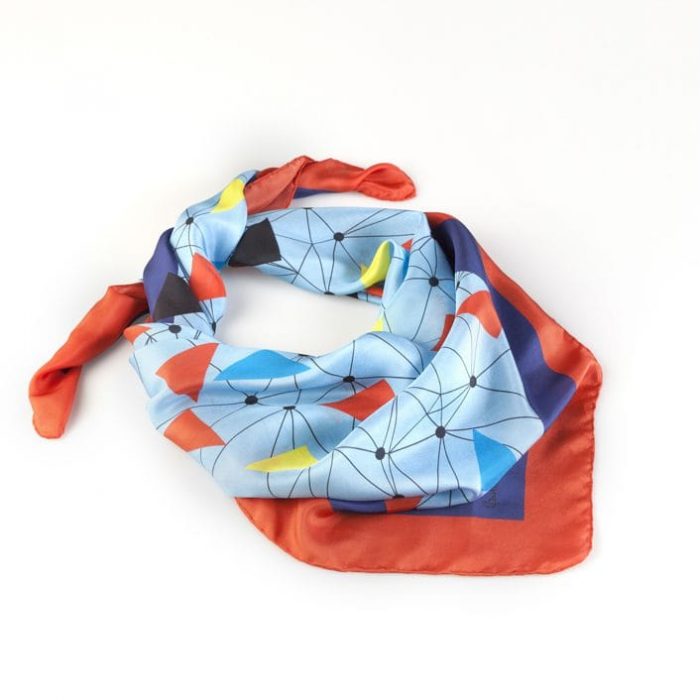 Folded 'Flying Macaws' scarf, emphasizing the unique abstract vision of macaw flocks in flight. Limited edition Barcelona design.