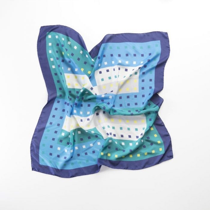 Abstract shot of the 'Patio de los Azulejos' scarf in blue, capturing the sense of water and tranquility evoked by the tiles and vegetation.