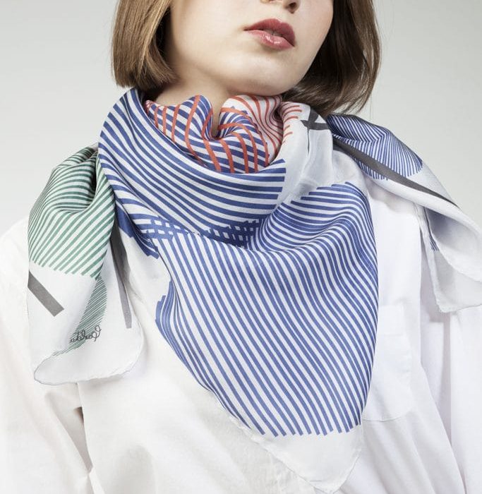 Abstract shot of the 'Sphere in the sky' scarf, capturing the interaction and movement inherent in the white, green, and blue design