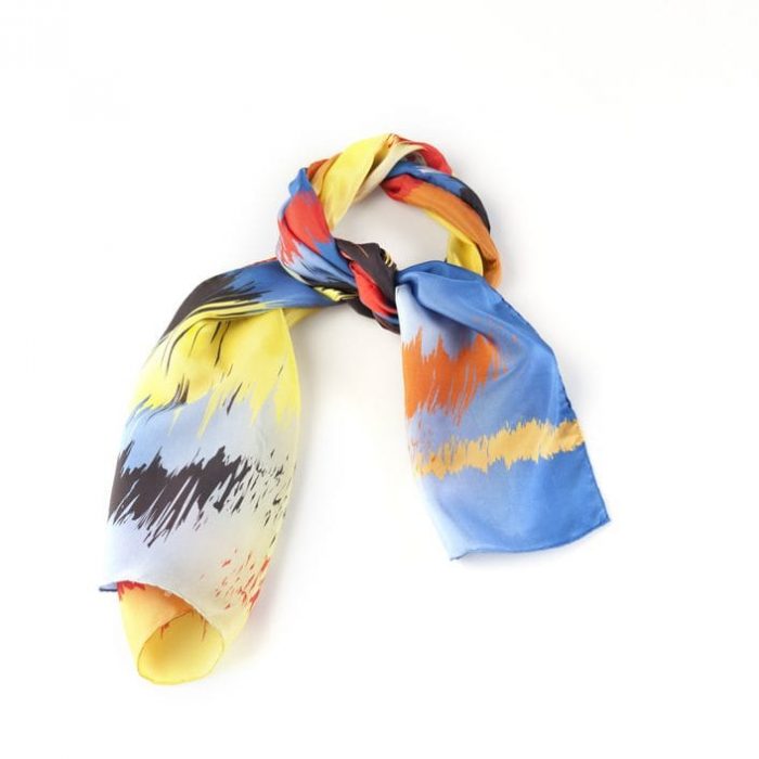 Close-up of the Sunset silk twill fabric, highlighting the rich texture and overlapping light spots motif in yellow and orange