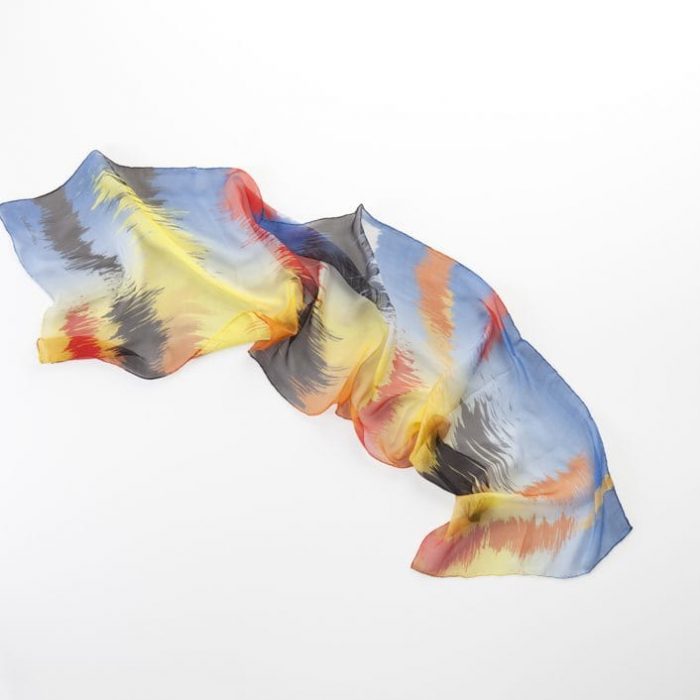 Carlota Bellés Sunset silk scarf (chiffon), lightweight fabric with vibrant yellow, orange, and blue abstract sunset design. Made in Spain.