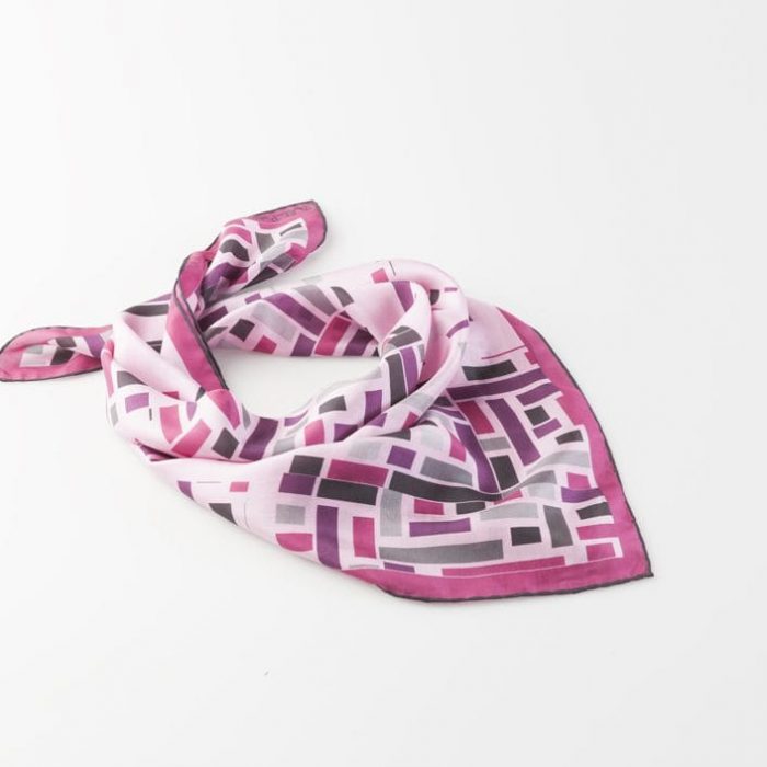 Silk Carlota Bellés Wild West silk scarf, featuring a dynamic pattern of diverse rectangles in purple and violet tones, symbolizing shared destiny in the city.