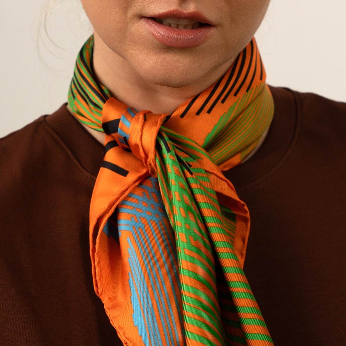 detalle de nudo pañuelo dre seda natural en tonos naranjas